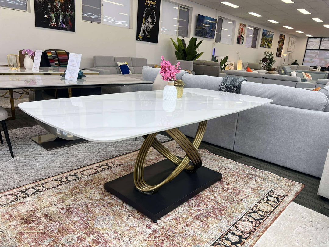 Modern white marble table with gold base in a living room setting