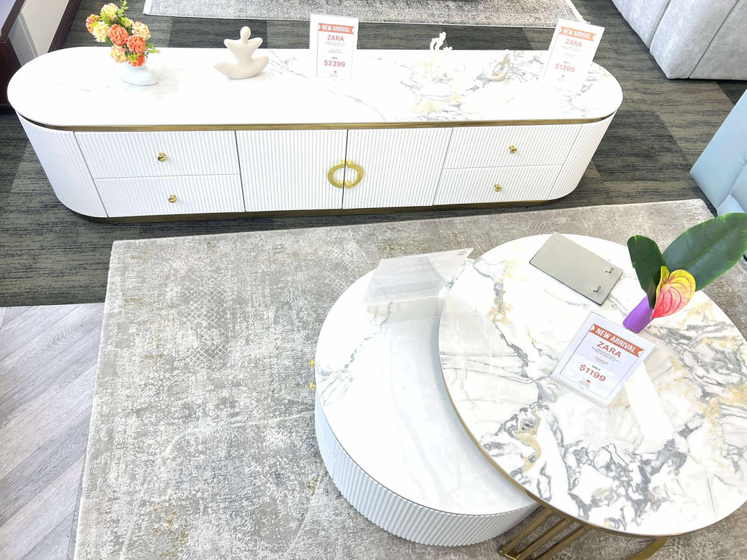 Modern living room with a white marble coffee table and decorative items.