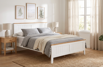 White wooden bed with gray bedding in a bright bedroom